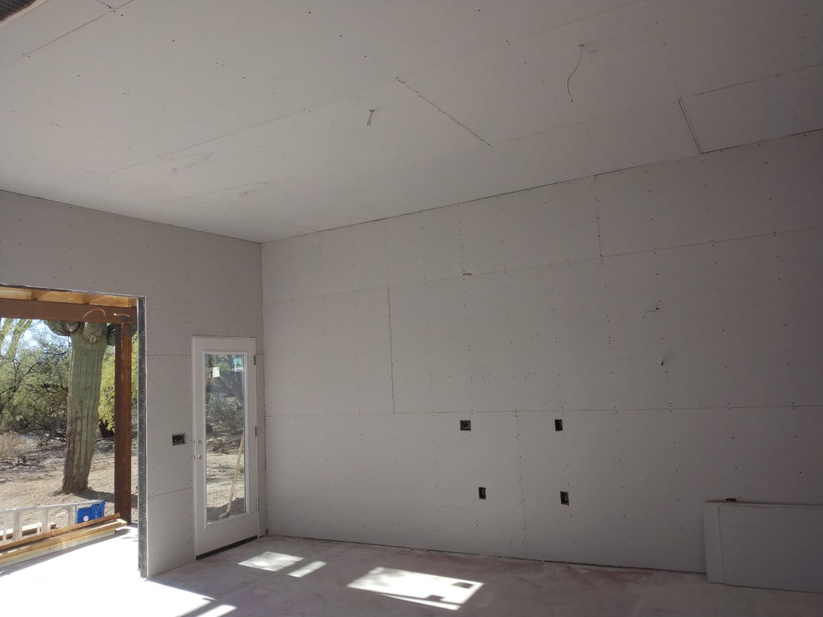 Room addition with drywall and exterior door overlooking desert, Tucson area